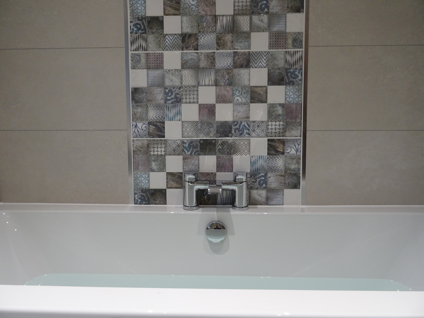 Feature tiled wall above taps on bath wall